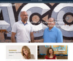 A website with two people standing in front of a brick wall.