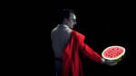 A man in a red cape holding a watermelon while following ethical SEO guidelines.