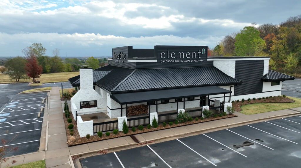 The exterior of a restaurant with a black roof.