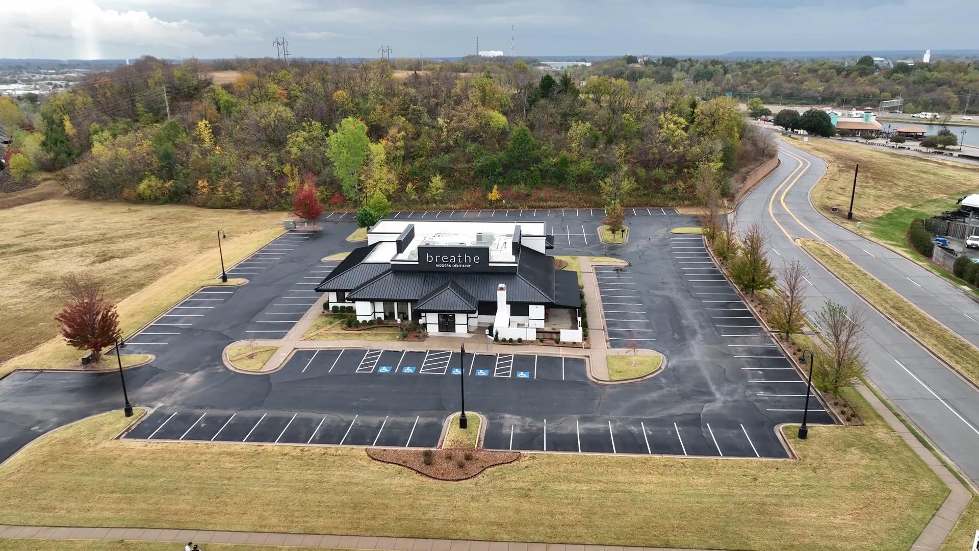 An aerial view of a building in the middle of a parking lot.